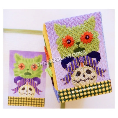 green cat face with red flower eyes with purple and yellow striped bow and white jackolantern on green floor with yellow polka dots