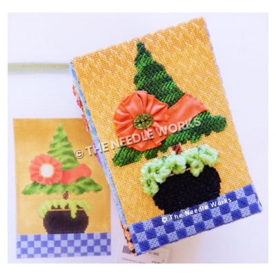 Christmas tree topiary with pink ribbon wrapped around with flower shape on orange background with blue checkered floor