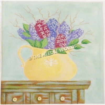 purple flowers in yellow vase on dresser with green background