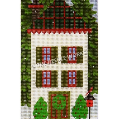 white two story house with green and red plaid roof and wreath on door with red birds on birdhouse and tall evergreens on each side
