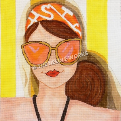 brunette closeup wearing orange and white head scarf with orange sunglasses in black swimsuit and yellow and white striped background