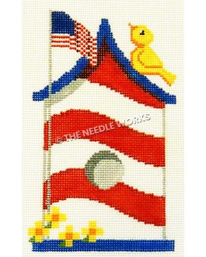 red and white striped birdhouse with blue roof and yellow bird on top of roof and American flag waving with yellow flowers at base of flag pole