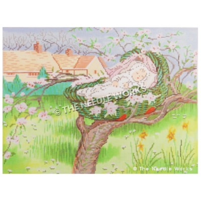 baby sleeping in basket in tree branch with pink flowers and field and houses with green fence in background