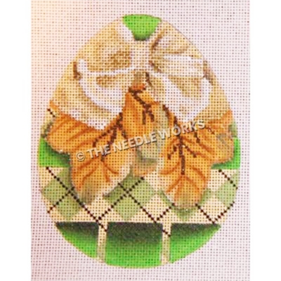 green and yellow egg with orange leaves and gold ribbon