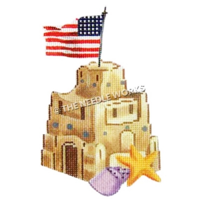 sand castle with American flag on top and purple seashell and starfish