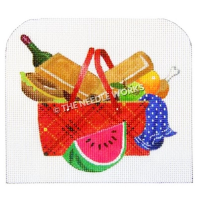 red, black and yellow plaid picnic basket overflowing with food, wine bottle, blue towel with white polka dots and slice of watermelon in front