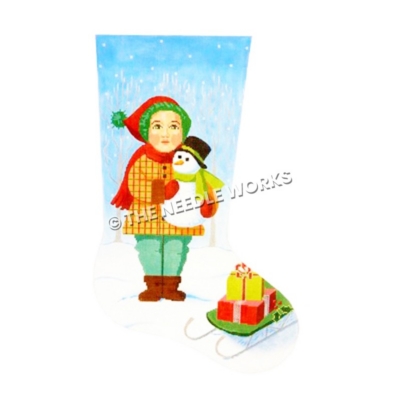 stocking of boy holding snowman standing in snow next to green sled with presents