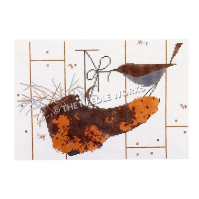 brown bird sitting on dirty brown shoe tugging on shoelace