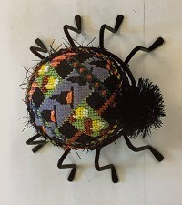 3D spider with patchwork pattern on back in purple, green, black, yellow and orange