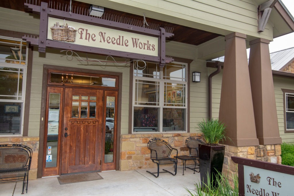 The Needle Works photograph of front entrance covered porch and sign