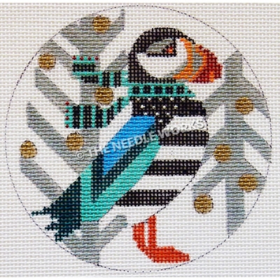 white round ornament with puffin wearing teal and black scarf and silver trees with gold round ornaments