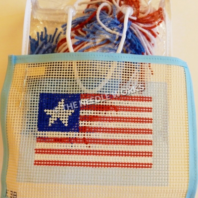 flag canvas with American flag pattern but one star and bag of red, white and blue yarn