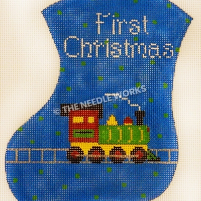 blue stocking with green polka dots with First Christmas in white and green, yellow and red train engine on track