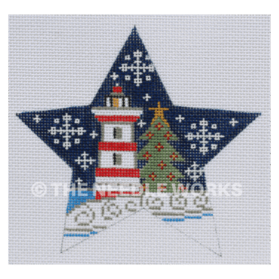 star with red and white lighthouse next to Christmas tree in snowscape with dark blue sky and snowflakes