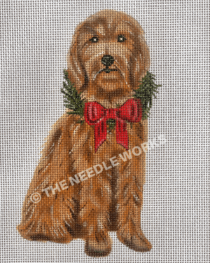 goldendoodle sitting and wearing wreath with red bow