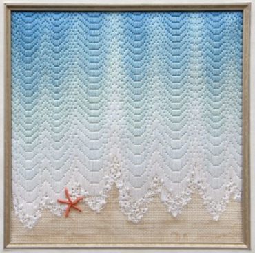 gold framed square with ocean water touching sand with orange starfish accent
