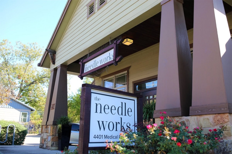 the needle works shop sign